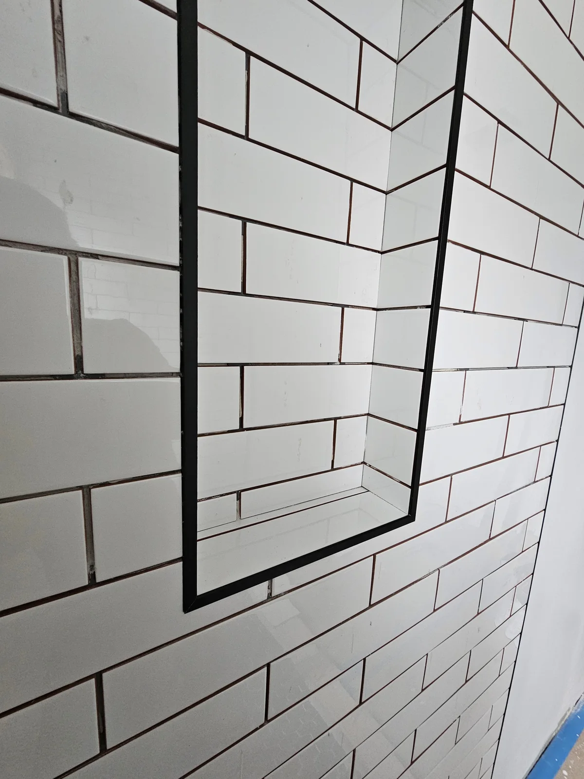 Finished Newburgh bathroom remodel with walk-in subway tile shower, black framed glass door, and black hex tile floor - photo 2