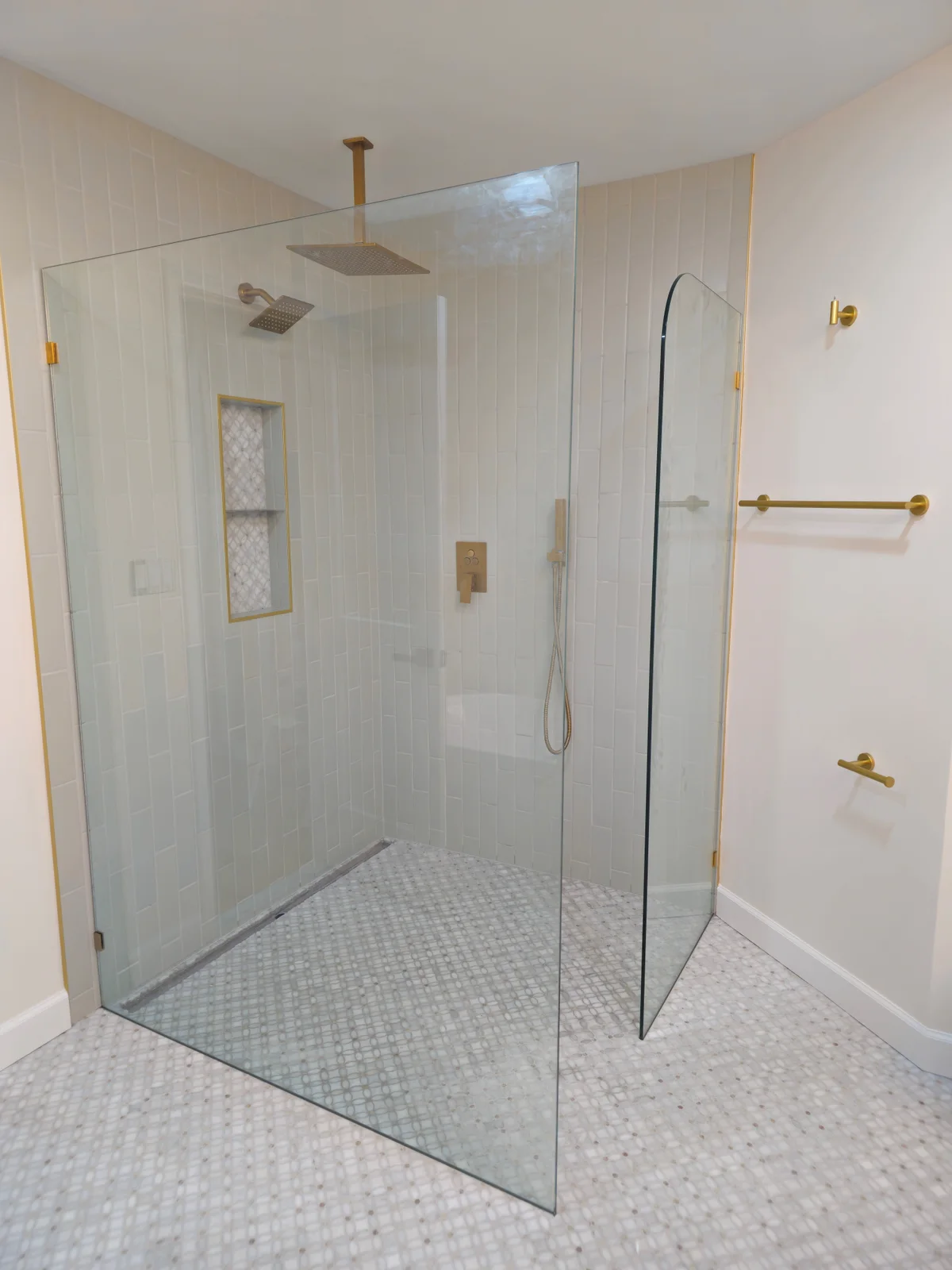 Finished Evansville bathroom remodel with dark green double vanity, arched mirrors, brass sconces, and freestanding tub - photo 1