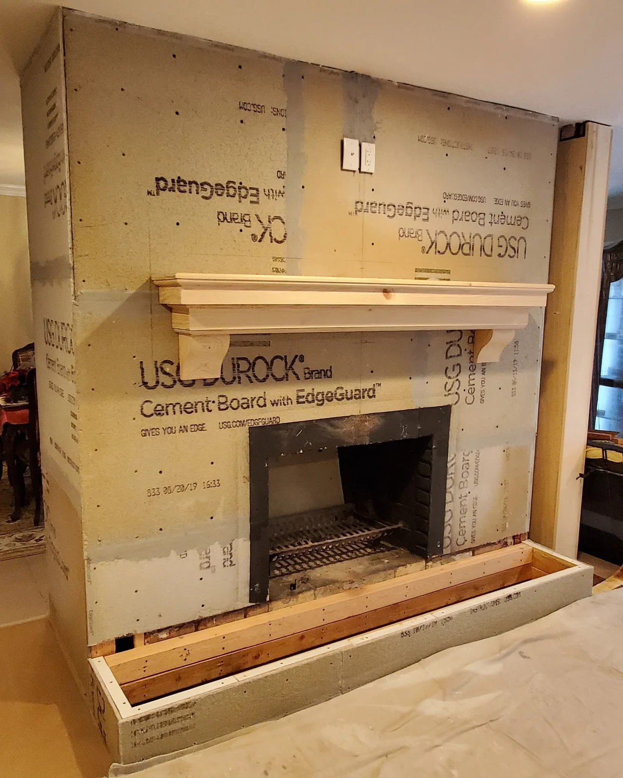 Finished Newburgh stone veneer fireplace with stacked stone surround, dark mantel, and raised hearth - photo 2