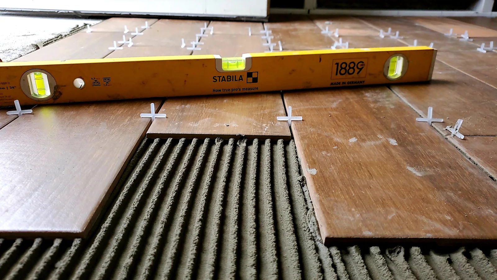 Finished wood-look tile flooring installed throughout a bright remodeled interior - photo 2